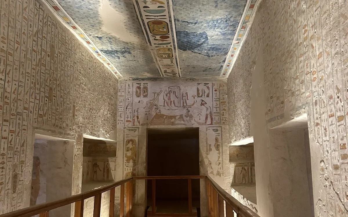 Corridoio dipinto di una tomba con soffitto decorato e ringhiere di legno