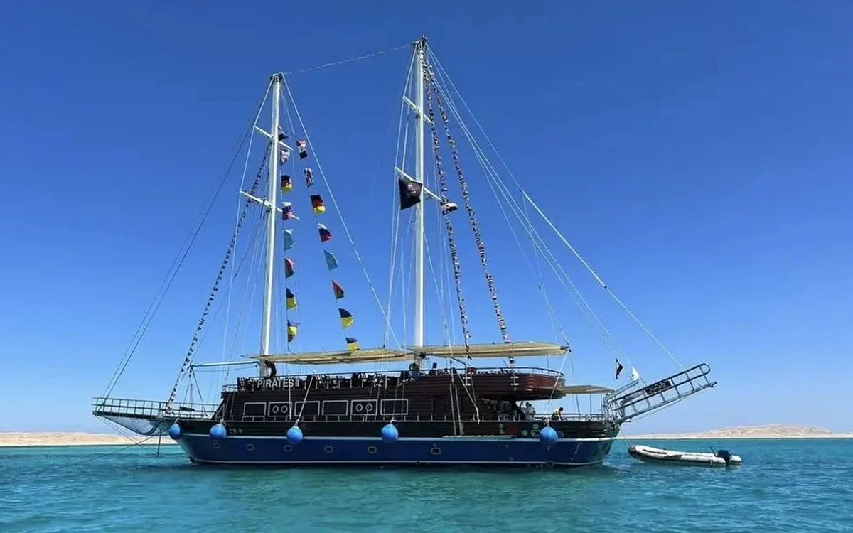 Nave turistica in legno a due alberi su acque turchesi