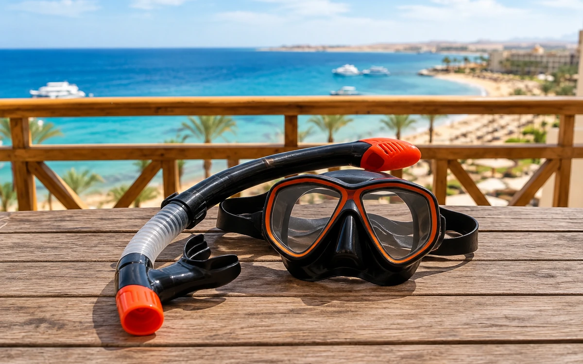 Eine Schnorchelmaske und ein Schnorchel auf einem Holzgeländer am Meer