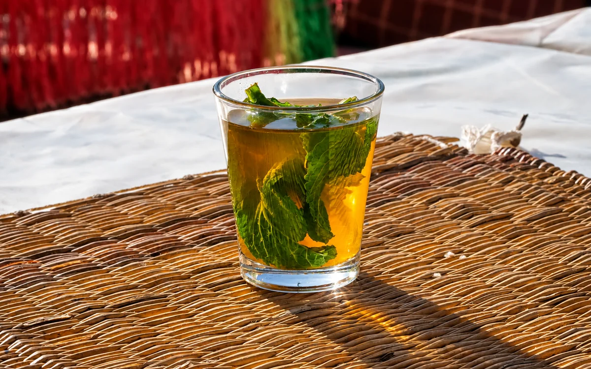Representative image: glass of tea with fresh mint on a woven mat